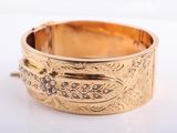 a close up of a gold bracelet with diamonds on it