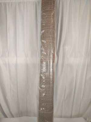 un rouleau de tissu posé par terre à côté d'un rideau