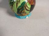 a vase that has a flower on it on a table