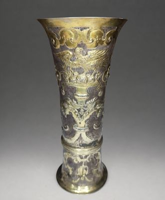 a silver and gold vase sitting on a table
