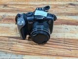 a camera sitting on a wooden table with a tag attached to it
