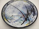 a plate with a painting on it sitting on a table