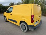 yellow van parked in a parking lot with trees in the background