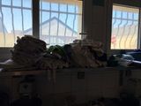 a pile of clothes sitting on a counter in front of a window