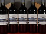 six bottles of wine are lined up on a table