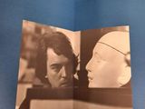 a person holding a book with a picture of a man and a woman