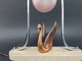 a sculpture of a swan and a pink ball on a stand