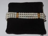 two rows of white pearls with gold accents on a black velvet bag