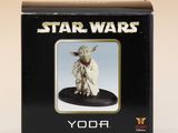une boîte contenant une figurine de Yoda de Star Wars posée sur une table