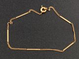 un bracelet plaqué or avec une chaîne sur un fond noir
