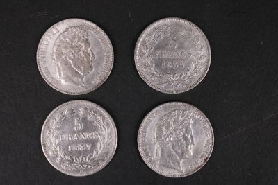 quatre pièces d'argent posées les unes à côté des autres sur une surface noire