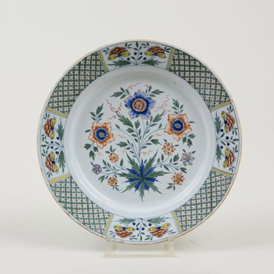 a plate with a floral design on it on a stand