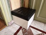 un pouf noir et blanc posé sur un sol en marbre