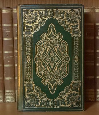 un vieux livre posé sur une étagère en bois, à côté d'une pile de livres