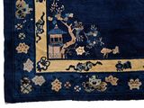 an image of a blue rug with a picture of a bird in a tree on it