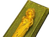 a gold statue of a woman on a green book