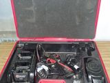une mallette rouge contenant deux postes de radio, posée sur une table en bois