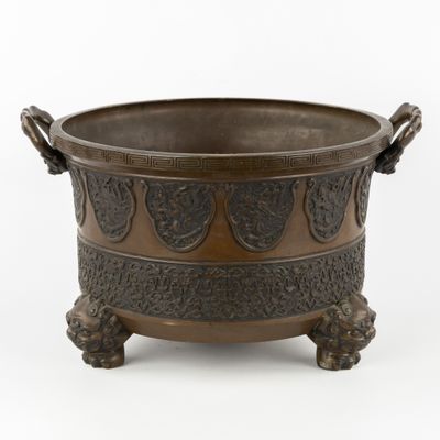 un bol ancien en bronze muni d'anses, sur fond blanc