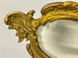 a mirror with a gold frame on a white surface