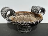 a black and white bowl with two handles on a table