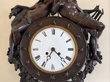 a clock that has a statue of two cherensils on it