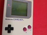 an old gameboy sitting on top of a red table