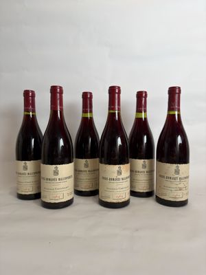 six bottles of wine are lined up on a table