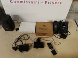 une pancarte indiquant « commissaire piseur » à côté d'un tas d'appareils électroniques