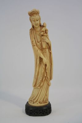 une figurine ancienne en ivoire sculpté représentant une femme tenant un bébé dans ses bras