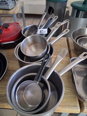 several pots and pans are lined up on a wooden table