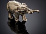 statue d'un éléphant sur une surface réfléchissante, avec un fond noir