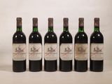 six bouteilles de vin sont alignées sur une surface blanche