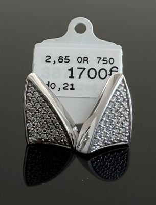 un gros plan sur une paire de boucles d'oreilles posées sur une table, avec une étiquette de prix