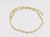 gros plan d'un bracelet en or sur une surface blanche