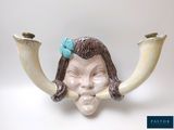 une figurine représentant une femme avec des cornes et un nœud sur la tête