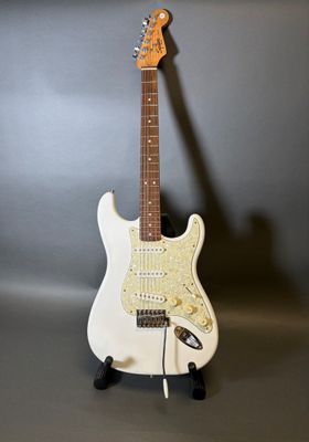 une guitare électrique posée sur une table près d'un mur