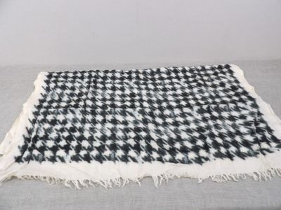 a black and white checkered blanket on a bed