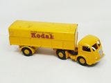 a yellow toy truck with a yellow trailer on a white surface