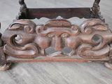a wooden table with carvings on it on a wooden floor
