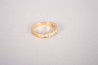 a close up of a gold ring with diamonds on a white surface