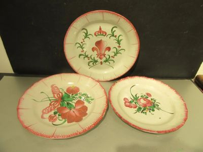 three plates with flowers on them on a table