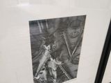 two framed pictures on the wall of a bathroom