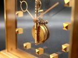 a gold clock that is on display in a glass case