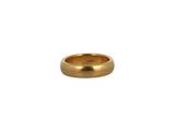 gros plan d'une bague en or sur fond blanc