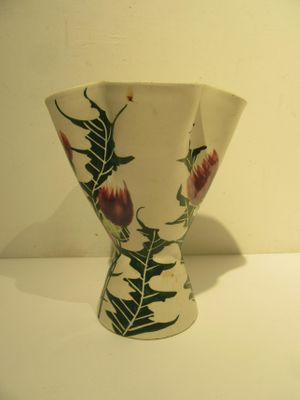 a white vase with a floral design on it on a table