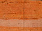 an orange, black, and white striped rug with a design on it