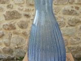 a blue vase sitting on top of a box on a wooden table