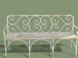 a white bench with a metal frame on a green background