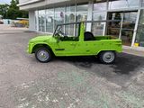 a small green car parked in front of a building