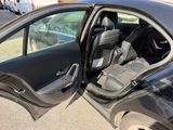 a black car with its door open on the side of the road